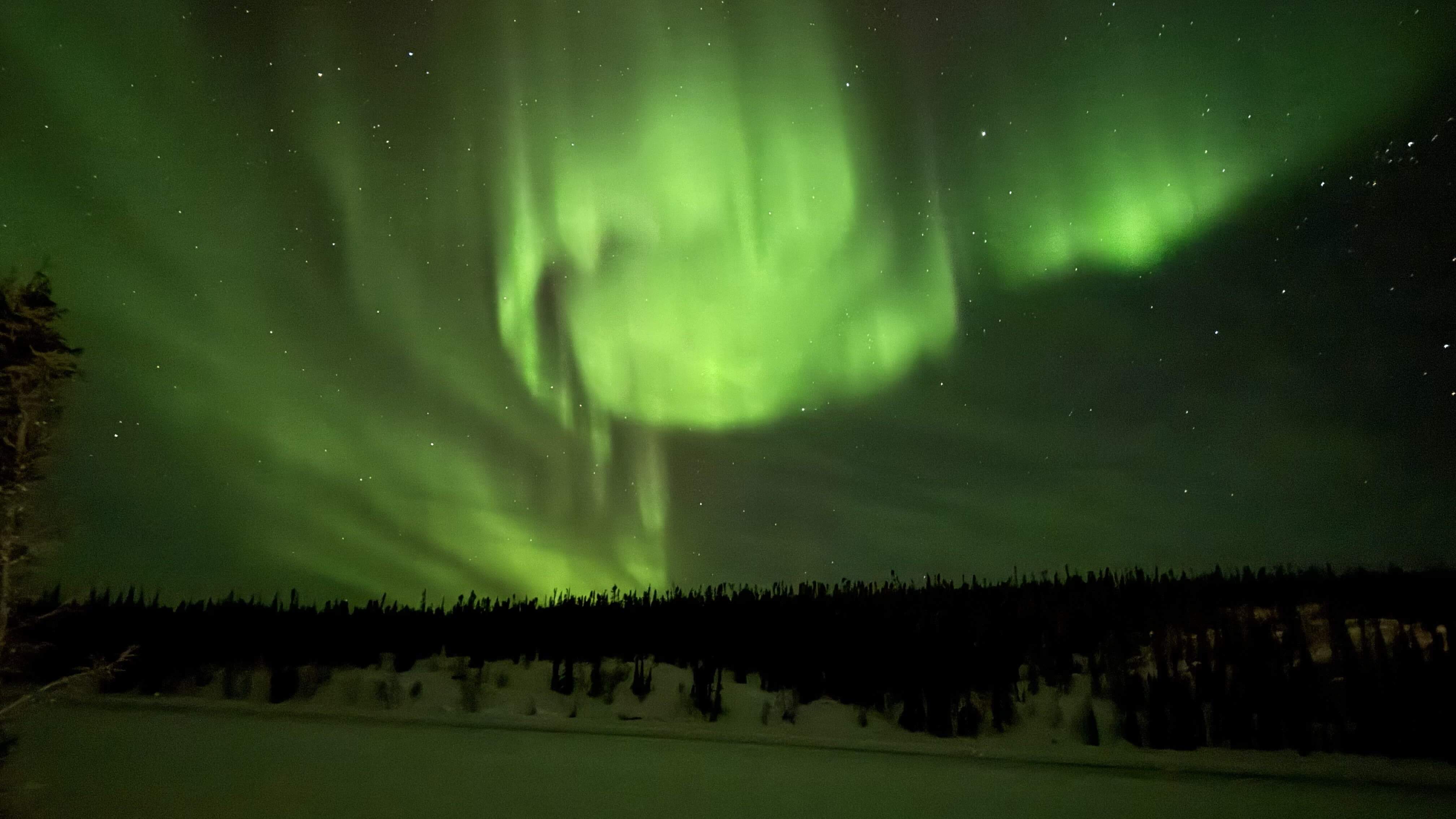 Aurora Borealis (northern lights) over the ice road at night.